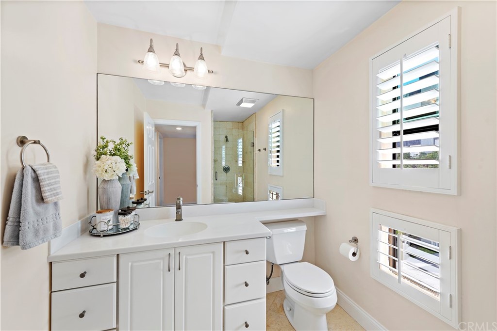 35232 Camino Capistrano, Unit 6 Dana Point, CA 92624 - Photo 18 of 25 a bathroom with a sink a toilet and a mirror