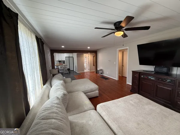 a kitchen with stainless steel appliances kitchen island granite countertop a refrigerator a stove a sink a dining table and chairs