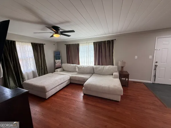 a living room with furniture and a wooden floor