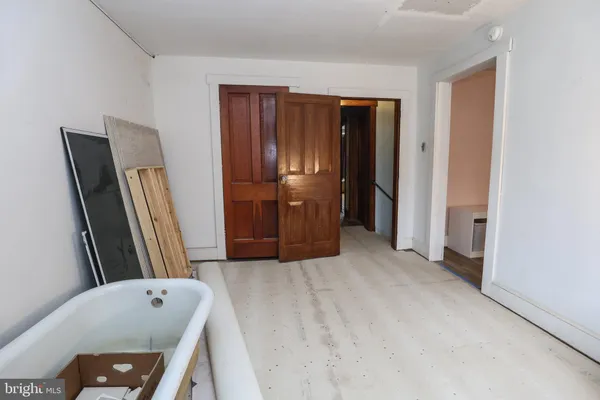 a view of a hallway with closet and mirror