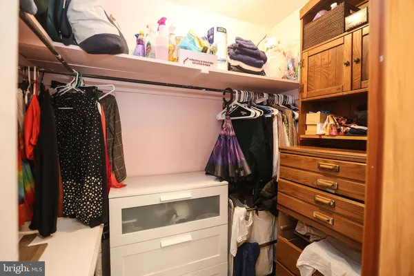 a view of walk in closet with clothes and shoes