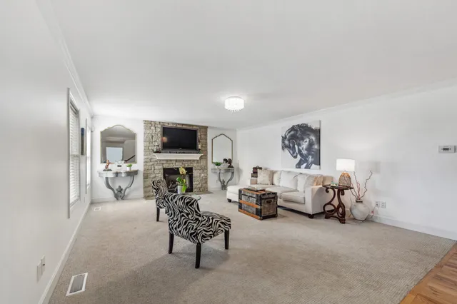 a large kitchen with kitchen island a sink a stove a refrigerator and a dining table with wooden floor