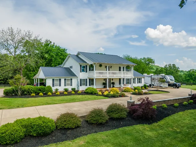 a front view of a residential apartment building with a yard and potted plants