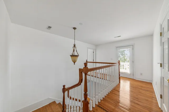an aerial view of a residential houses with outdoor space and trees all around