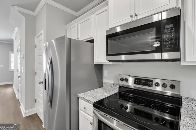a kitchen with stainless steel appliances a stove a microwave and cabinets