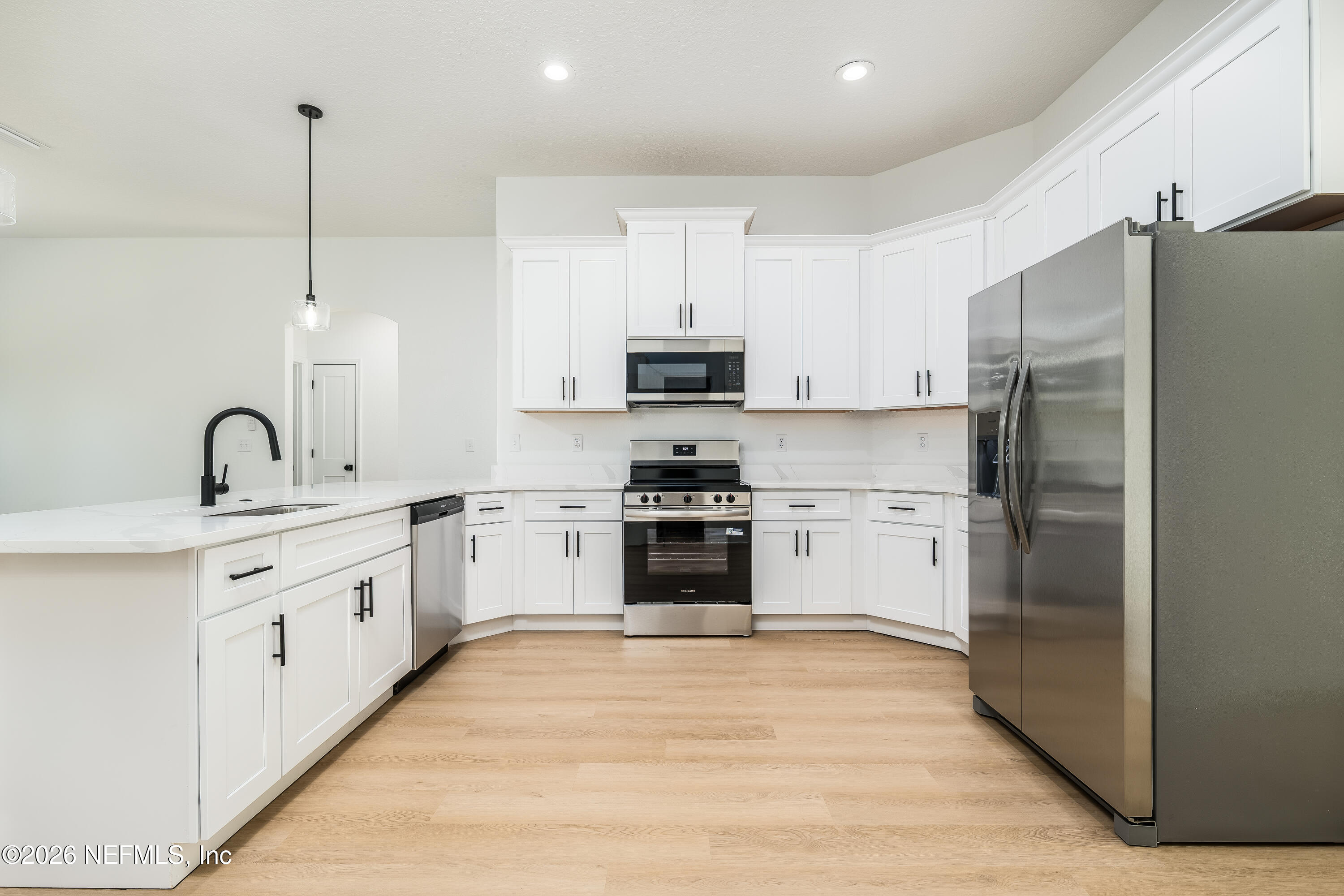 4455 Southeast 3rd Place Keystone Heights, FL 32656 - Photo 4 of 25 a kitchen with white cabinets and stainless steel appliances