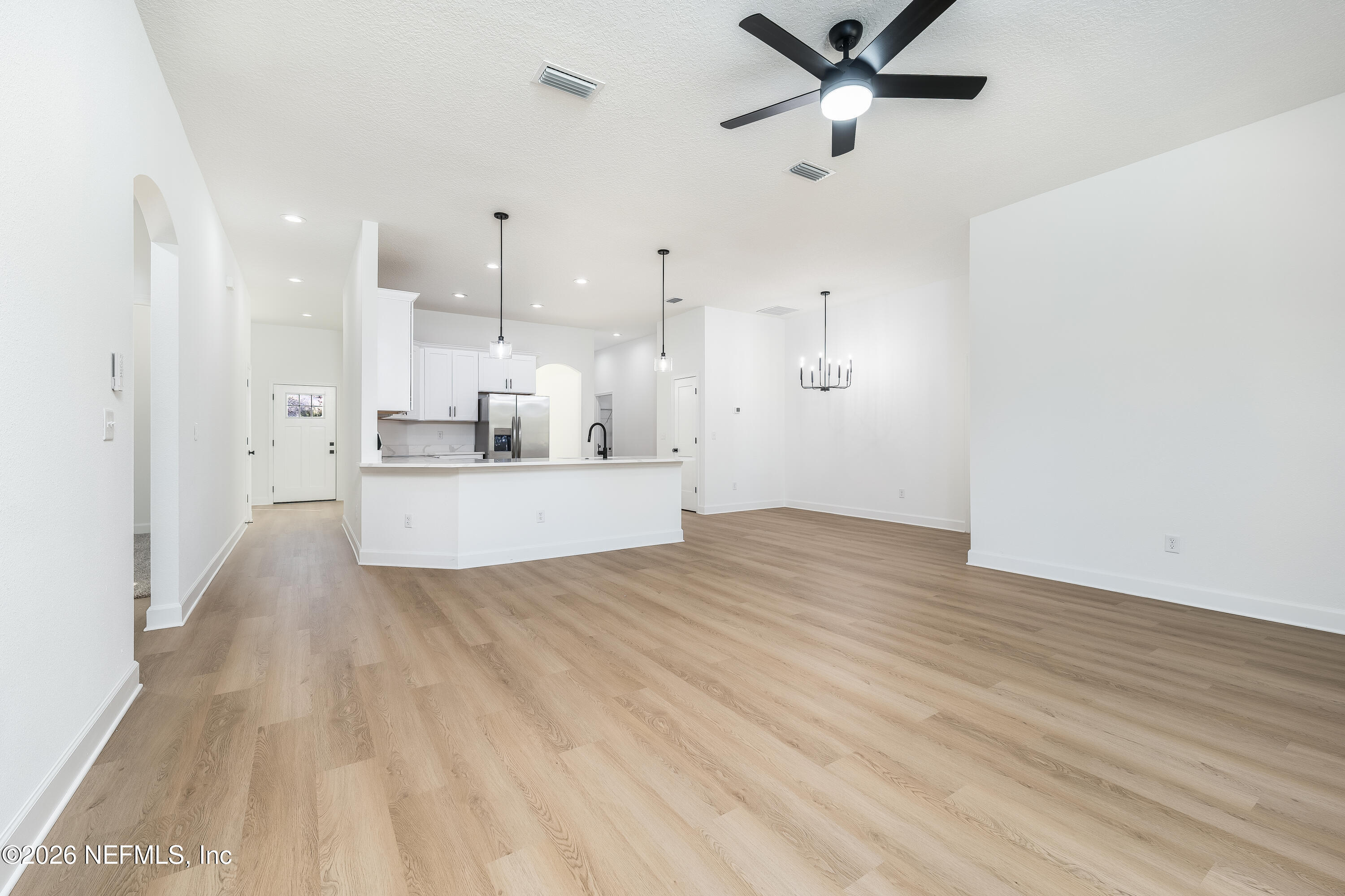 4455 Southeast 3rd Place Keystone Heights, FL 32656 - Photo 5 of 25 a view of a kitchen with kitchen island a sink wooden floor and a window