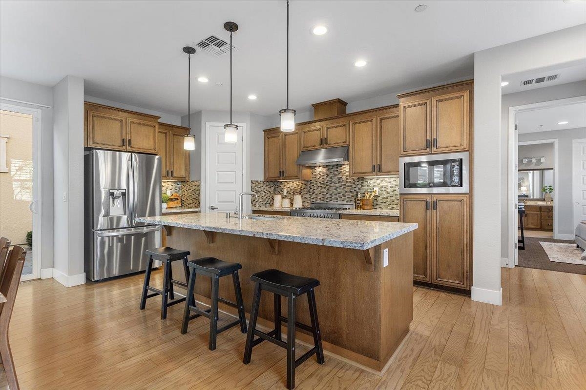 406 Mosley Avenue Alameda, CA 94501 - Photo 13 of 60 a kitchen with stainless steel appliances granite countertop a refrigerator a oven a sink a dining table and chairs with wooden floor