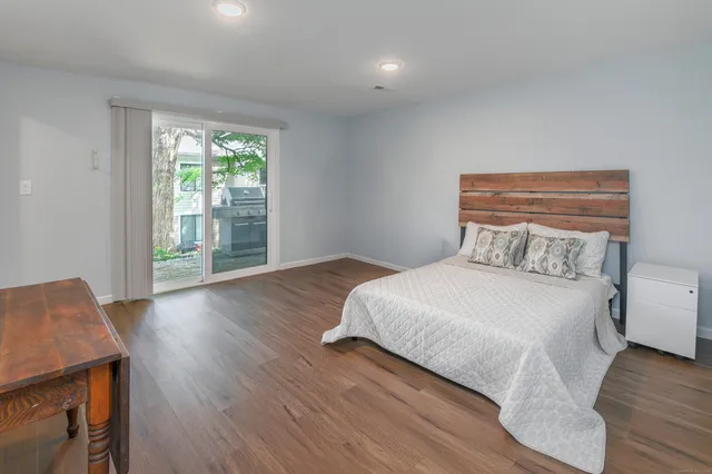 a bedroom with a bed and wooden floor