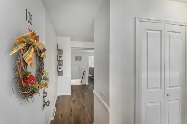 a view of a hallway with wooden floor and closet