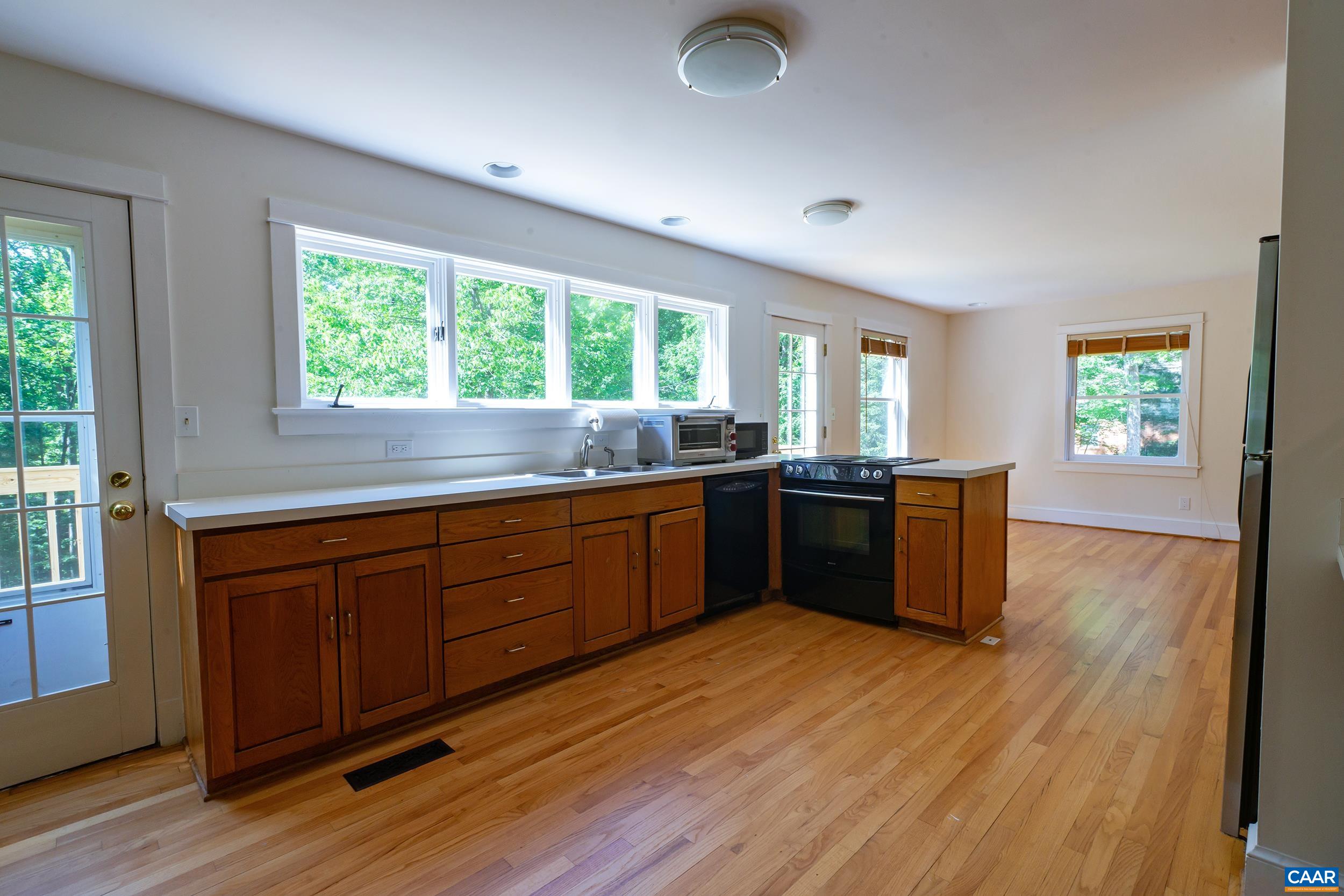 2601 Cardinal Ridge Road Charlottesville, VA 22901 - Photo 12 of 50 a kitchen with granite countertop a stove a sink a window and wooden floor