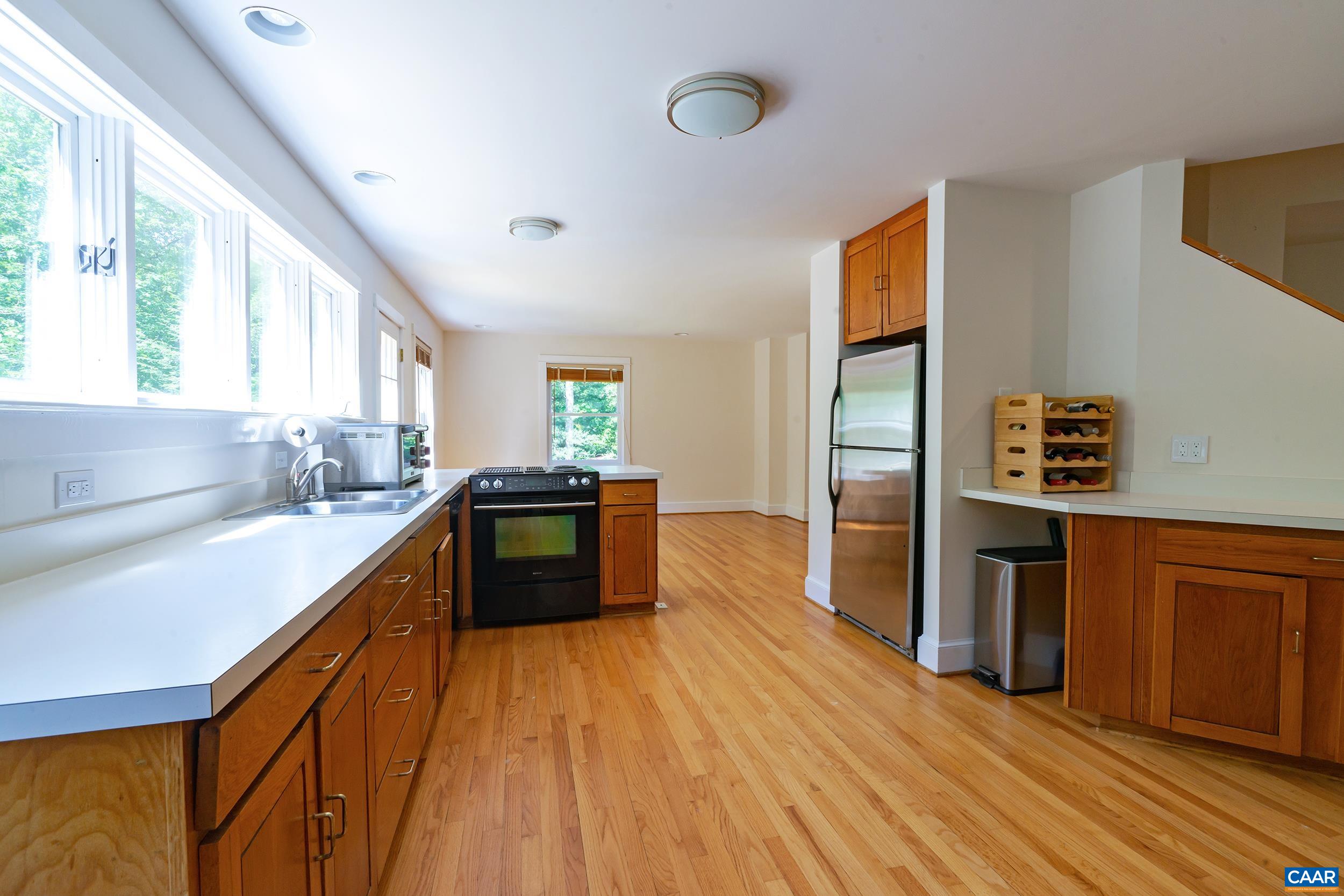2601 Cardinal Ridge Road Charlottesville, VA 22901 - Photo 13 of 50 a kitchen with stainless steel appliances wooden floors and wooden cabinets