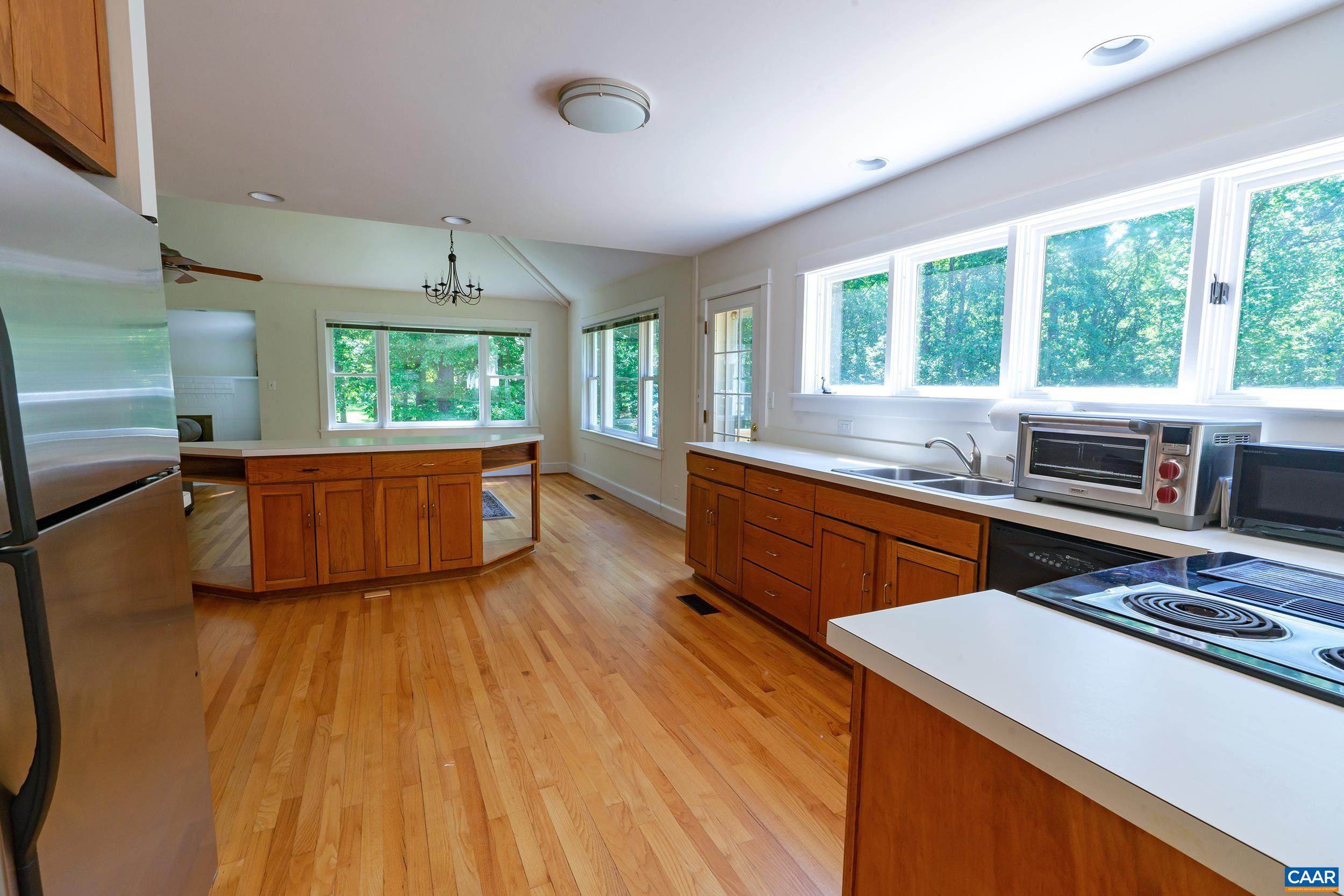 2601 Cardinal Ridge Road Charlottesville, VA 22901 - Photo 16 of 50 a kitchen with stainless steel appliances a stove a sink dishwasher and a microwave oven with wooden floor