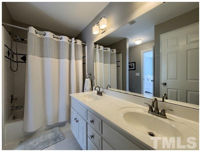 8000 Kukui Court Raleigh, NC 27613 - Photo 21 of 25 a bathroom with double vanity sink and a mirror