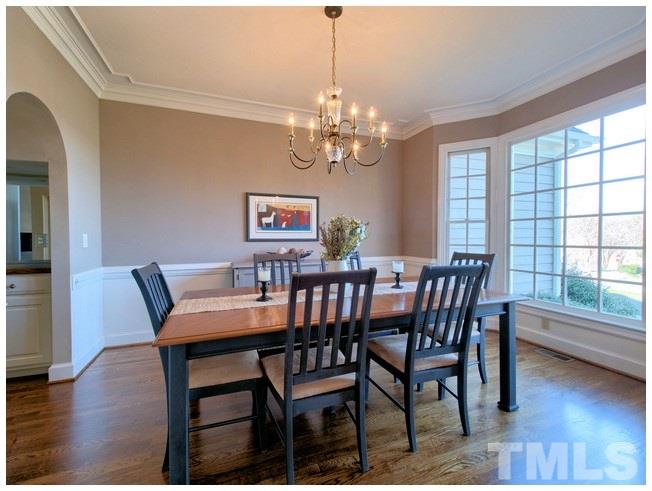 8000 Kukui Court Raleigh, NC 27613 - Photo 7 of 25 a view of a dining room with furniture a chandelier and wooden floor
