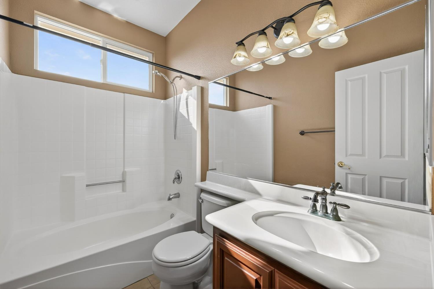 1716 Presidio Way Plumas Lake, CA 95961 - Photo 32 of 43 a bathroom with a granite countertop sink a toilet and shower