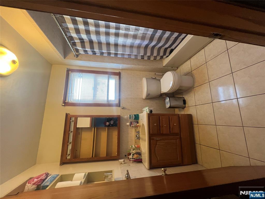 68 Atlantic Street Carteret, NJ 07008 - Photo 23 of 38 a bathroom with a sink a toilet and a shower