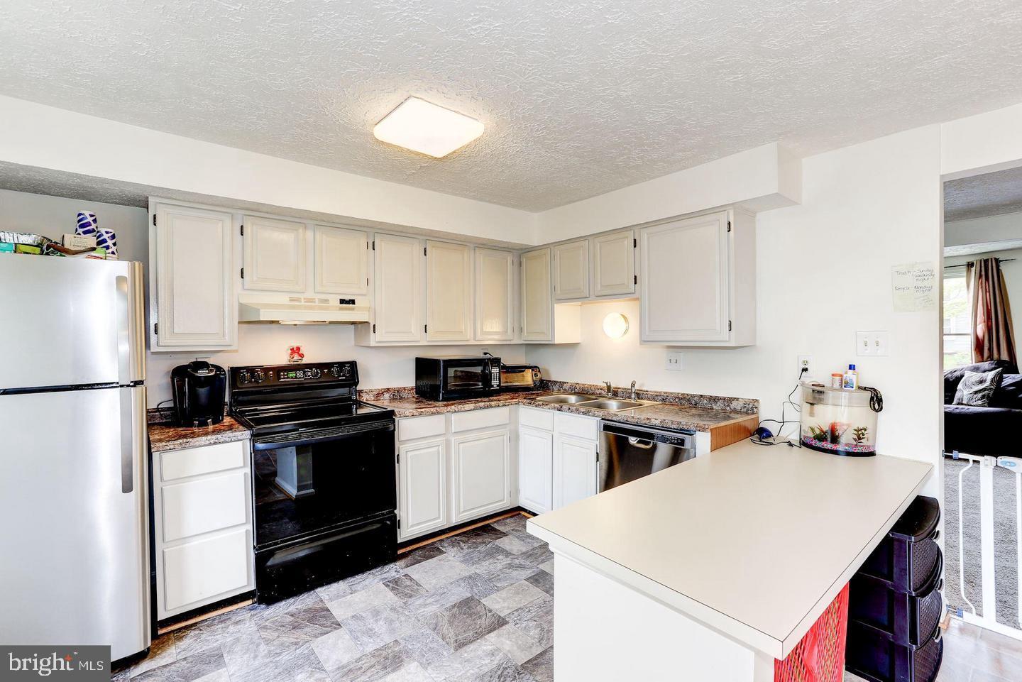 10117 Shelldrake Circle Damascus, MD 20872 - Photo 7 of 14 a kitchen with a white stove top oven and refrigerator