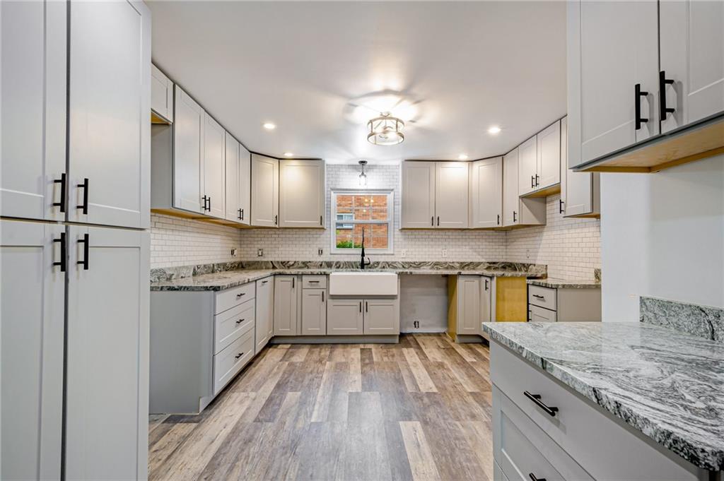 1611 Branning Road Pittsburgh, PA 15235 - Photo 17 of 38 a kitchen with granite countertop a sink cabinets stainless steel appliances and a counter top space