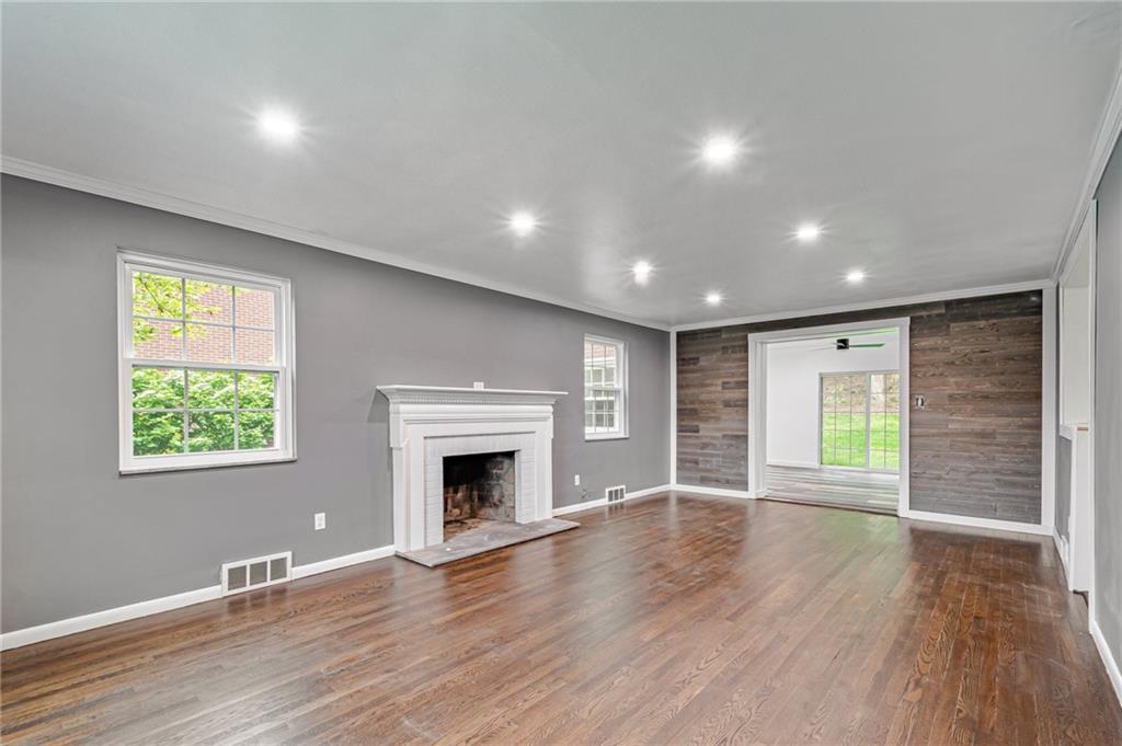 1611 Branning Road Pittsburgh, PA 15235 - Photo 4 of 38 an empty room with wooden floor fireplace and windows