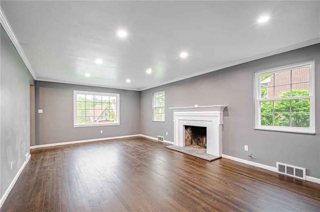 1611 Branning Road Pittsburgh, PA 15235 - Photo 7 of 38 an empty room with wooden floor fireplace and windows