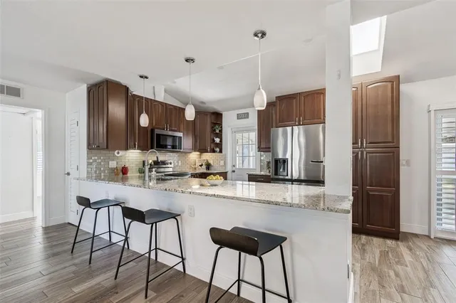 a kitchen with stainless steel appliances granite countertop a sink and stove top oven