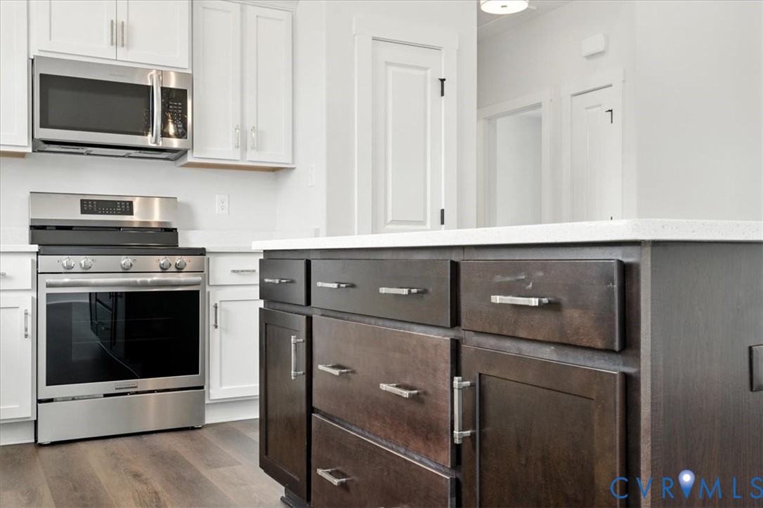 8666 Hat Creek Road Brookneal, VA 24528 - Photo 23 of 38 a kitchen with stainless steel appliances white cabinets and stove