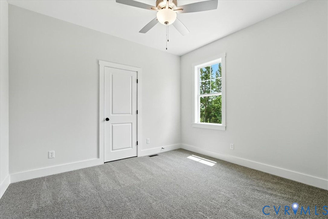 8666 Hat Creek Road Brookneal, VA 24528 - Photo 27 of 38 an empty room with chandelier fan and windows