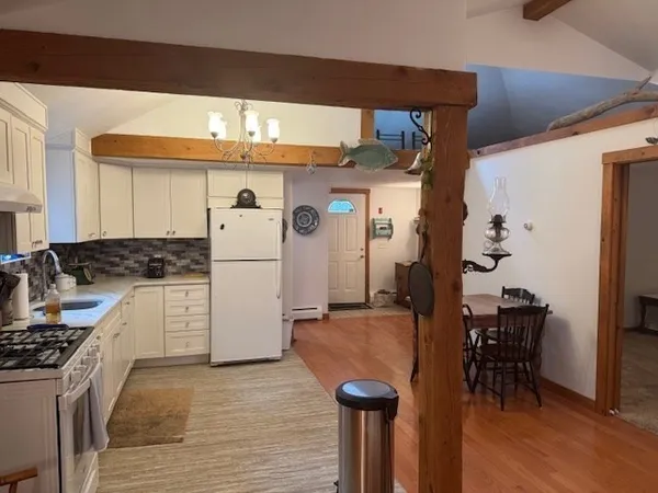 a kitchen with stainless steel appliances granite countertop a refrigerator a stove a sink and white cabinets