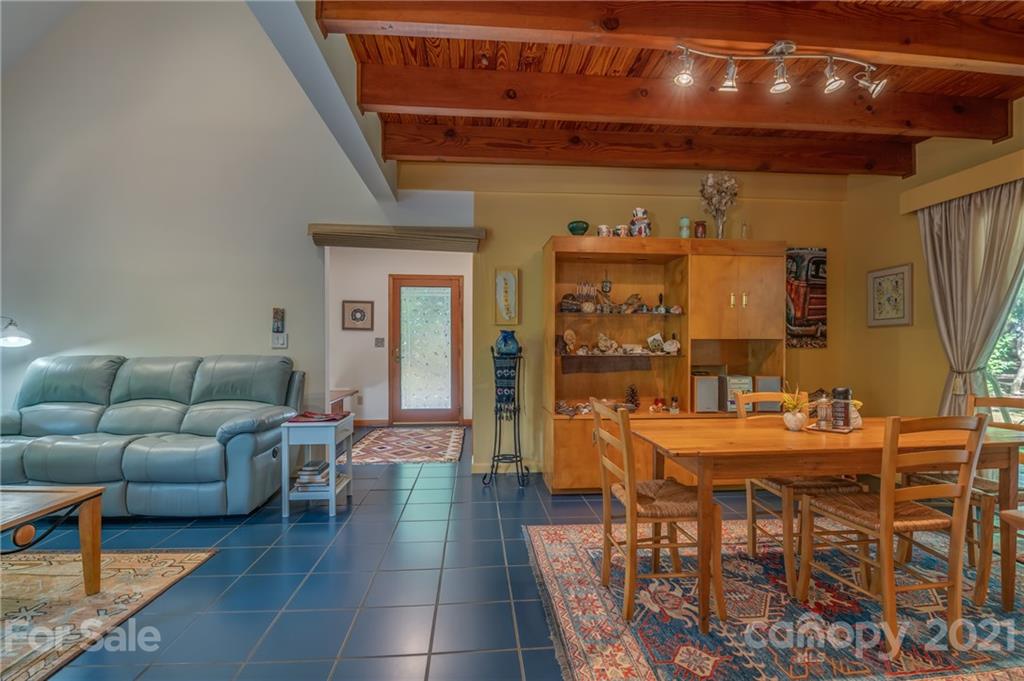 127 Pink Campbell Road, Unit 3B Landrum, SC 29356 - Photo 7 of 46 a living room with furniture a chandelier and a dining table