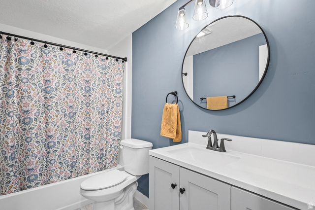 1588 West Rim Rock Drive Stockton, UT 84071 - Photo 33 of 61 Bathroom featuring a white vanity with a single sink and matte black faucet, a large round mirror, and a white toilet