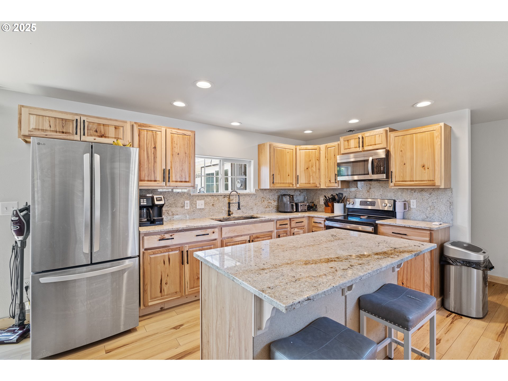765 State Street North Bend, OR 97459 - Photo 12 of 46 a kitchen with granite countertop a refrigerator a stove a sink dishwasher and white cabinets with wooden floor