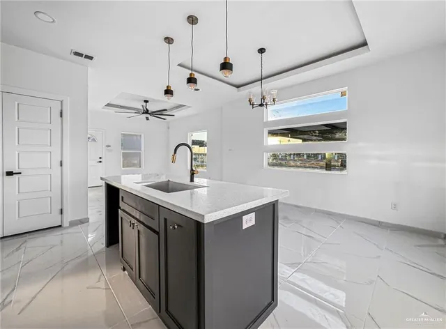a kitchen with kitchen island a sink a stove and a refrigerator with wooden floor