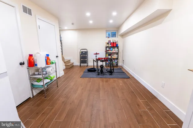 an empty room with wooden floor and dining table