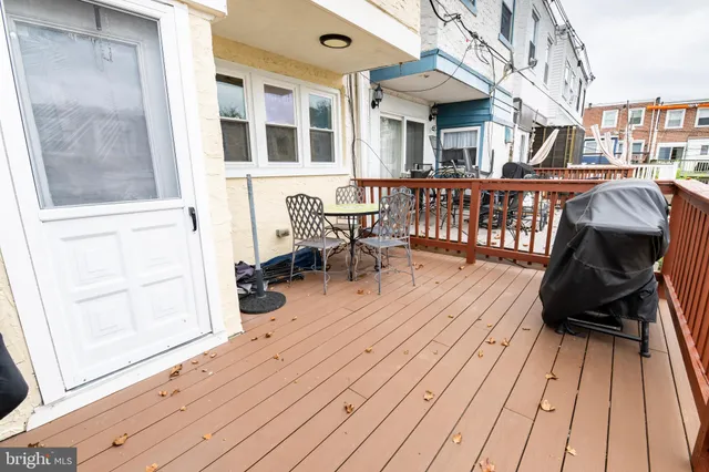 a view of a roof deck with table and chairs with wooden floor and fence