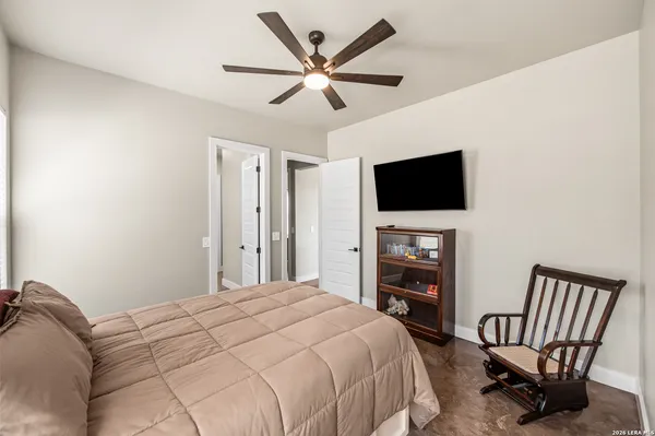 a bedroom with a bed a flat screen tv and a couch