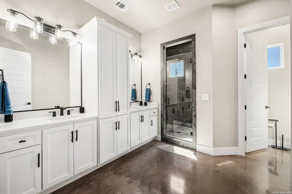 a large bathroom with a double vanity sink a large mirror and shower