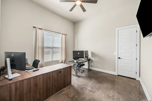 a view of a workspace with furniture and a window