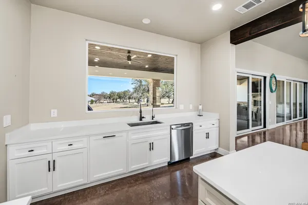 a kitchen with stainless steel appliances a sink a stove a refrigerator and cabinets