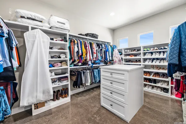 a view of walk in closet with clothes and shoes