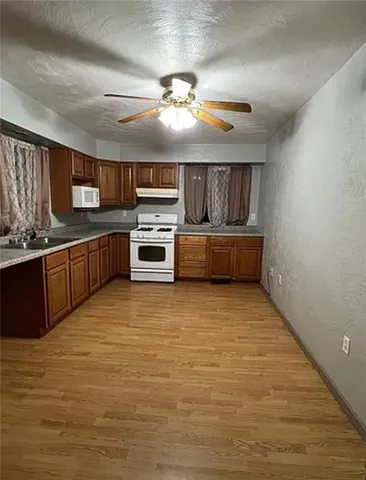a large kitchen with cabinets a sink and stainless steel appliances