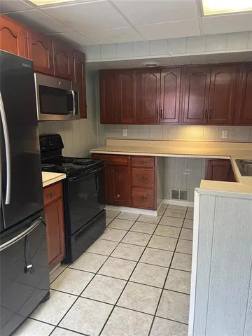 a kitchen with stainless steel appliances granite countertop a refrigerator and a stove top oven