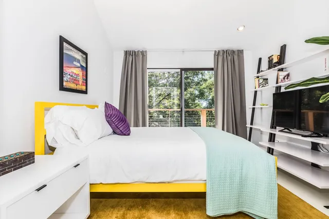 a bed sitting in a bedroom next to a window