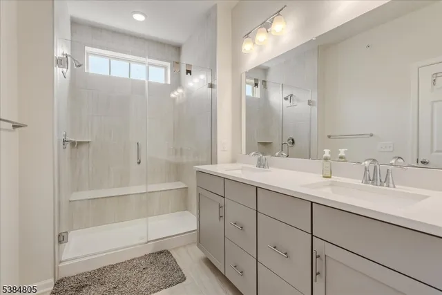 a bathroom with a double vanity sink mirror double and shower