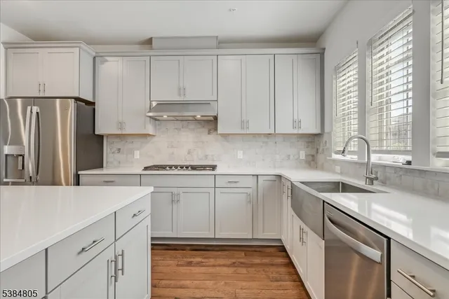 a kitchen with cabinets appliances a sink and a window