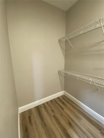 a view of an empty room with furniture and a kitchen