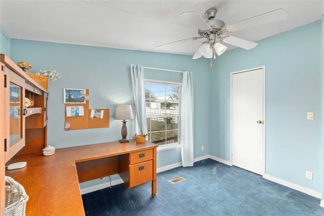 a room with chandelier fan and a window