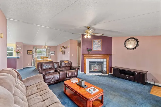 a living room with furniture a fireplace and a window