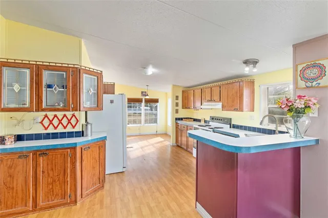 a kitchen with stainless steel appliances granite countertop a stove and a wooden cabinets