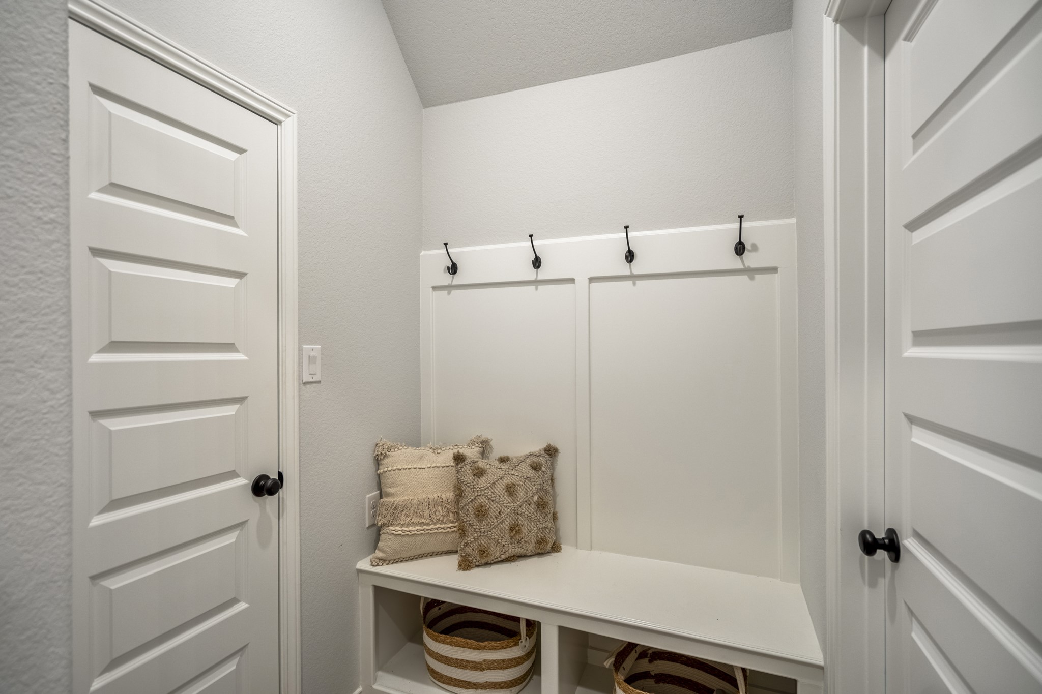 334 Topper Pines Drive Montgomery, TX 77316 - Photo 33 of 49 Pulling back to see the full mud drop zone, this front-entry alcove adds a helpful landing spot with hooks, bench seating, storage below, and the walk-in coat closet just beside it. The door on the right leads us into the laundry room.